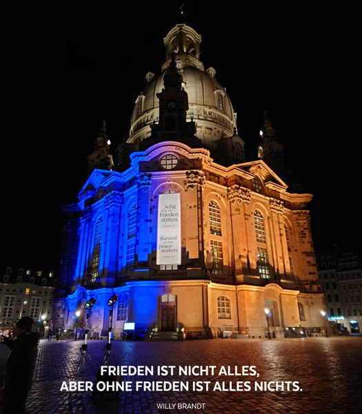 Dresdener Frauenkirche in den blau-gelbem Licht mit Zitat von Willy Brandt - Frieden ist nicht alles, aber ohne Frieden ist alles nichts.