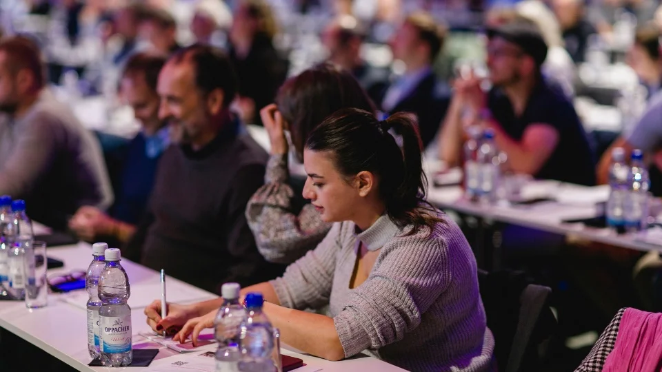 Fokus auf eine Notizenschreiberin im Publikum