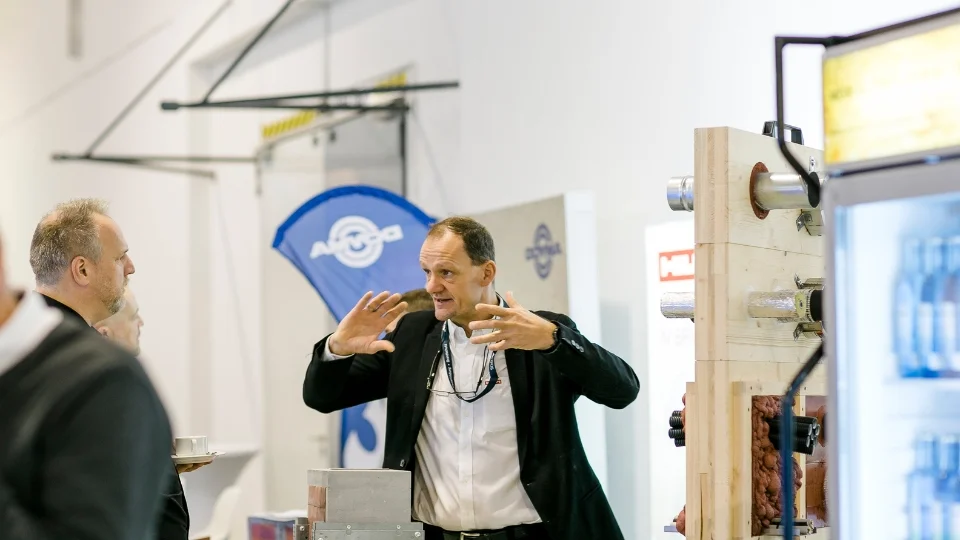 Aufnahme aus der Austellung - Besucher und Standbetreuer in ein Gespräch vertieft